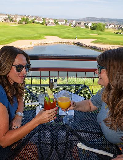 People having drinks at the Clubhouse Grill overlooking the golf course.